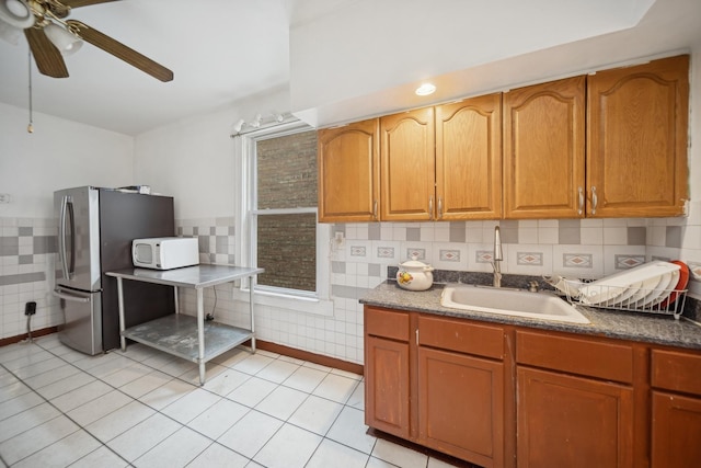 kitchen with ceiling fan, stainless steel fridge, sink, and light tile patterned floors