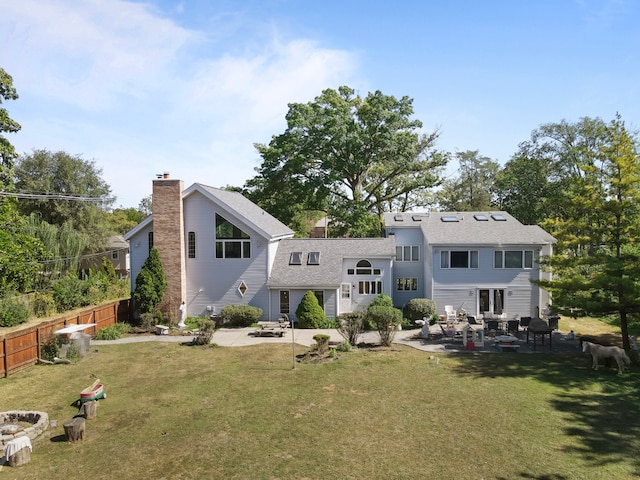 back of house with a patio, a lawn, and a fire pit