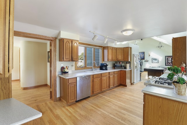 kitchen featuring stainless steel appliances, track lighting, light wood-type flooring, and sink