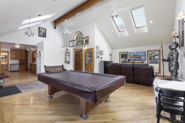 recreation room featuring a skylight, high vaulted ceiling, and ceiling fan
