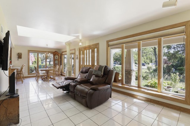 living room with light tile patterned flooring and a notable chandelier
