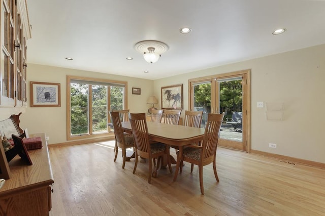 dining space featuring baseboards, visible vents, a wealth of natural light, and light wood-style floors