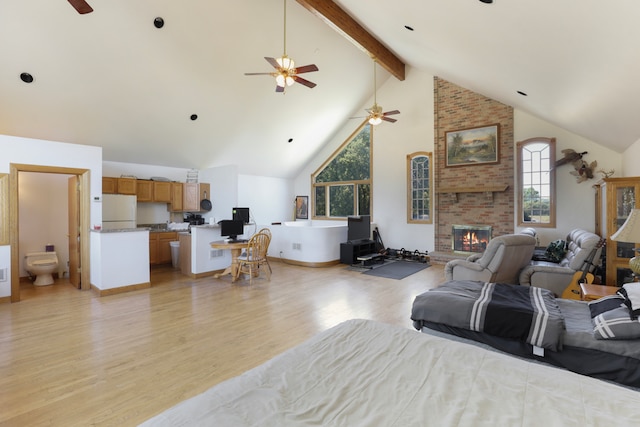 bedroom with light hardwood / wood-style floors, high vaulted ceiling, beamed ceiling, white fridge, and ceiling fan