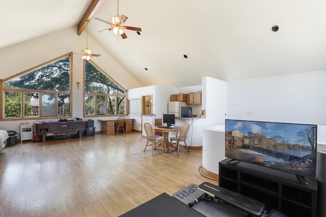 living room with light wood-type flooring, beamed ceiling, ceiling fan, and high vaulted ceiling