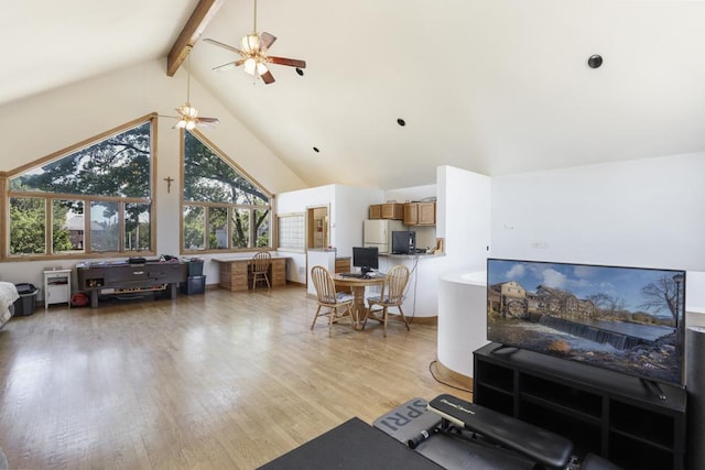living area featuring lofted ceiling with beams, a ceiling fan, and light wood finished floors