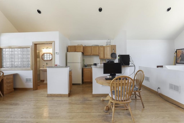 kitchen featuring freestanding refrigerator, visible vents, and light wood finished floors