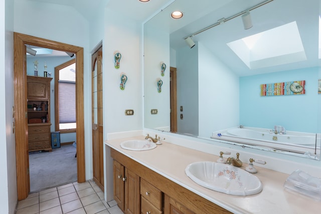 bathroom featuring lofted ceiling with skylight, vanity, and tile patterned floors