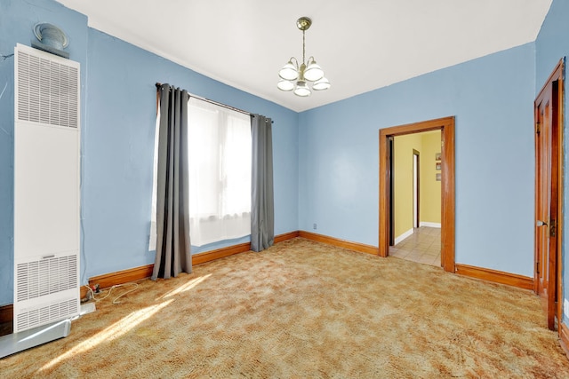 carpeted spare room featuring a notable chandelier