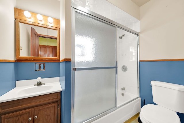 full bathroom featuring combined bath / shower with glass door, vanity, and toilet