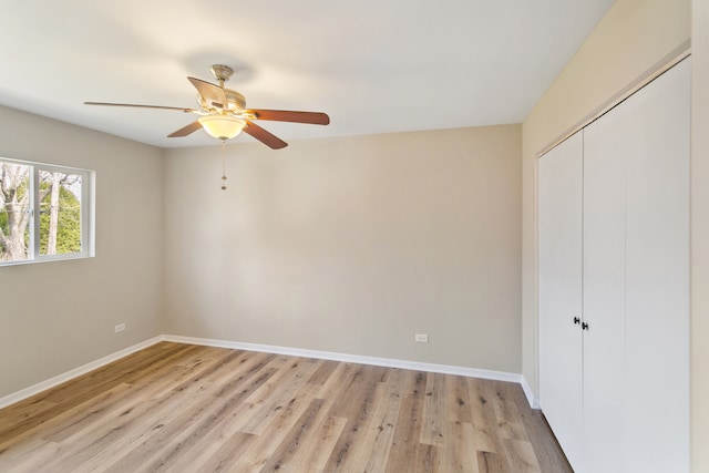 unfurnished bedroom featuring ceiling fan, a closet, and light hardwood / wood-style floors