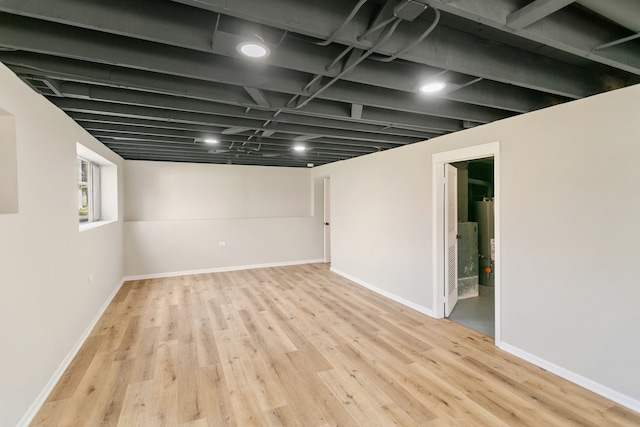 basement featuring gas water heater and light hardwood / wood-style flooring