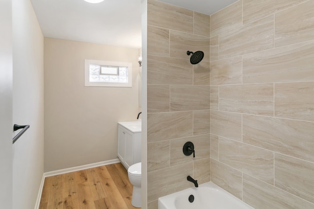 full bathroom featuring hardwood / wood-style floors, vanity, tiled shower / bath combo, and toilet