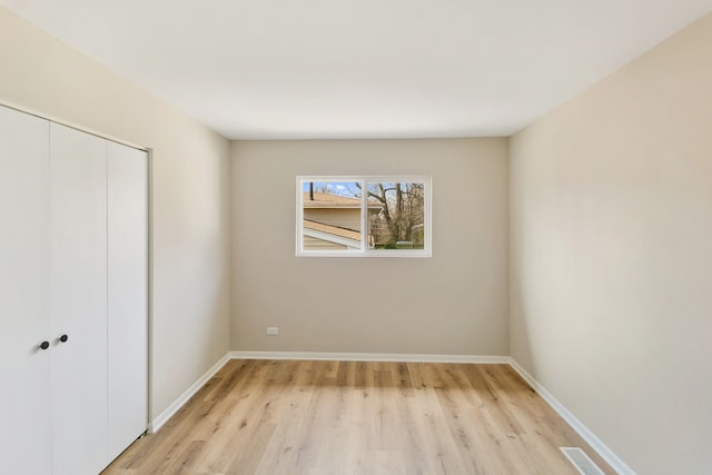 unfurnished bedroom featuring a closet and light hardwood / wood-style flooring