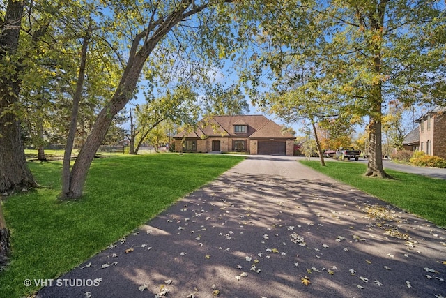 view of front of house featuring a garage and a front lawn