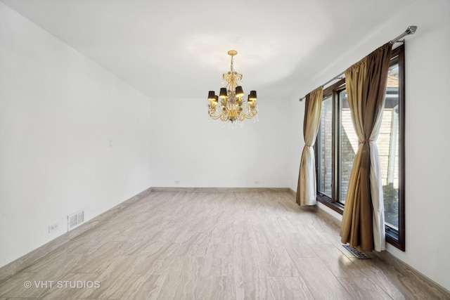 unfurnished room featuring a notable chandelier and light hardwood / wood-style floors