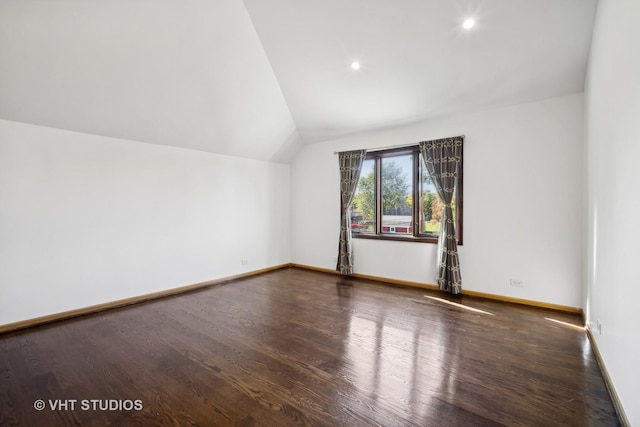 additional living space featuring lofted ceiling and dark hardwood / wood-style floors