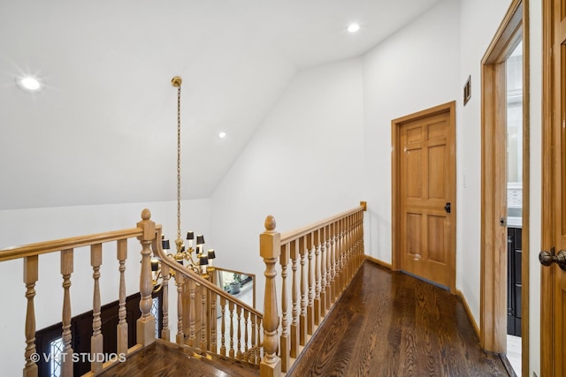 hallway with dark hardwood / wood-style floors and vaulted ceiling