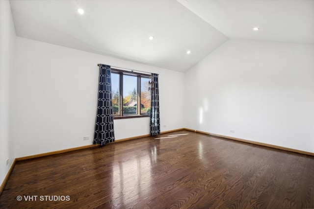 empty room featuring vaulted ceiling and hardwood / wood-style floors