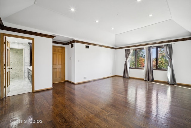 empty room featuring ornamental molding, wood-type flooring, and a raised ceiling