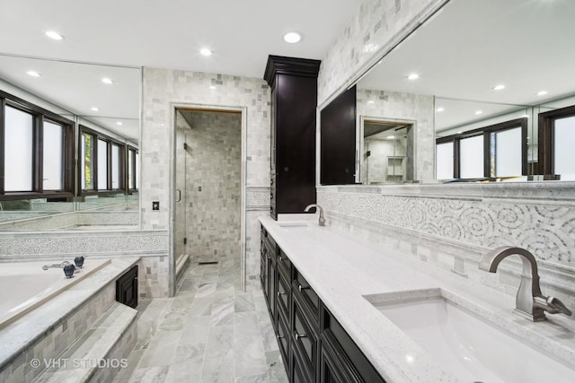 bathroom with vanity, independent shower and bath, and tile walls