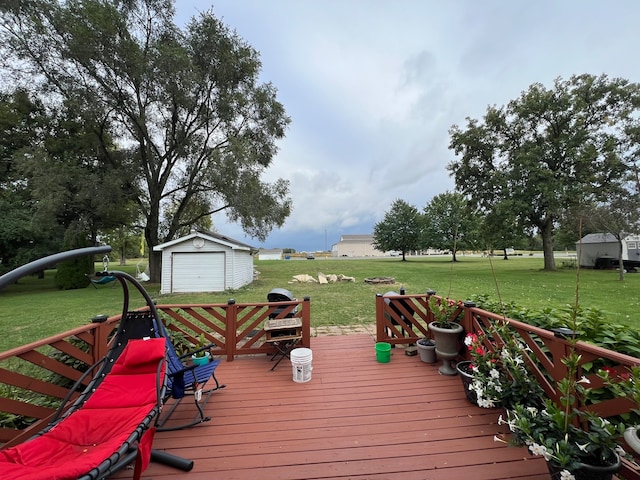 wooden deck featuring an outdoor structure, a garage, and a lawn