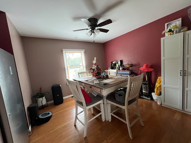 dining space with light wood-type flooring and ceiling fan