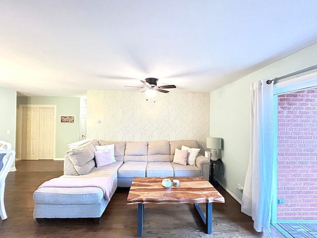 living room featuring ceiling fan and dark hardwood / wood-style floors