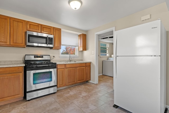 kitchen with washer / clothes dryer, appliances with stainless steel finishes, and sink