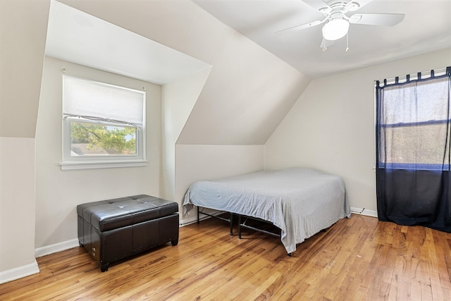 bedroom with ceiling fan, lofted ceiling, light hardwood / wood-style floors, and multiple windows