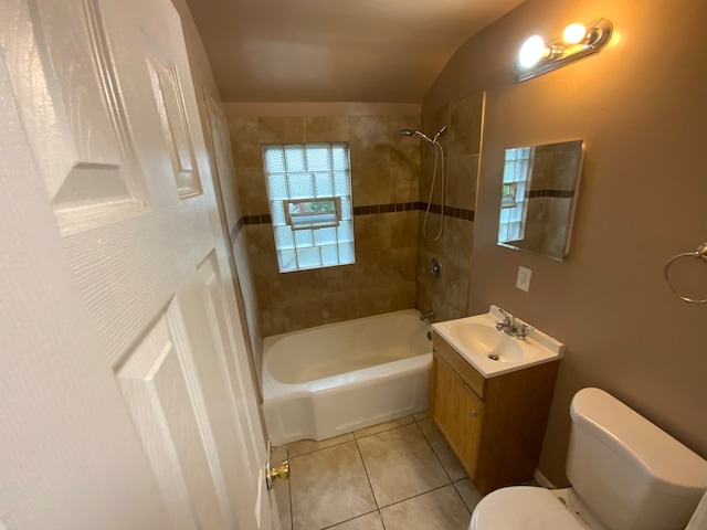 full bathroom with lofted ceiling, tiled shower / bath combo, vanity, and toilet