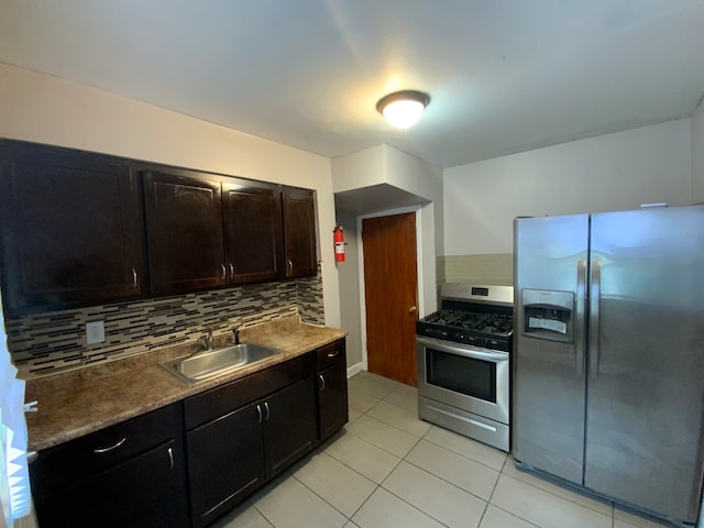 kitchen featuring light tile patterned flooring, sink, dark brown cabinets, appliances with stainless steel finishes, and decorative backsplash