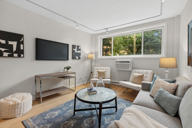 living room with wood-type flooring, track lighting, and a wall mounted AC