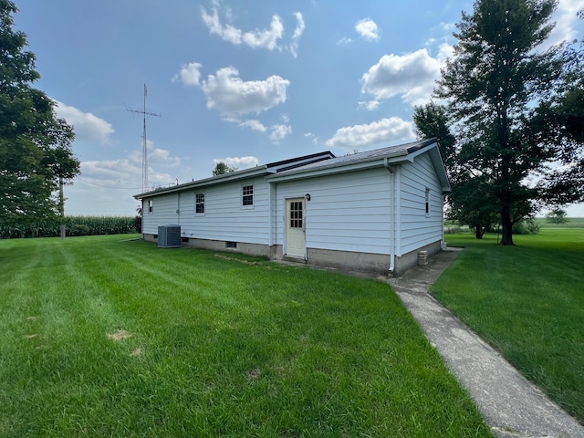 rear view of house featuring a lawn and central AC unit