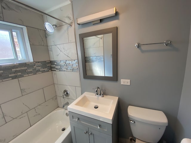 full bathroom with tiled shower / bath combo, vanity, toilet, and ornamental molding