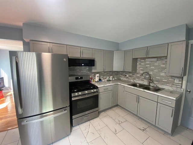 kitchen featuring gray cabinetry, stainless steel appliances, tasteful backsplash, and sink