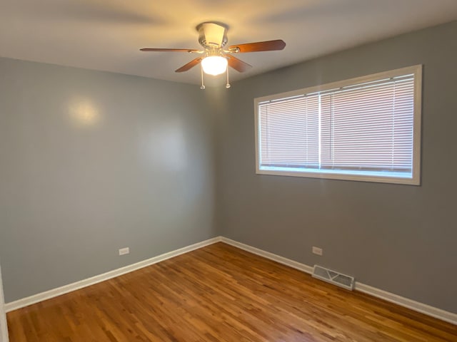 empty room with ceiling fan and hardwood / wood-style flooring