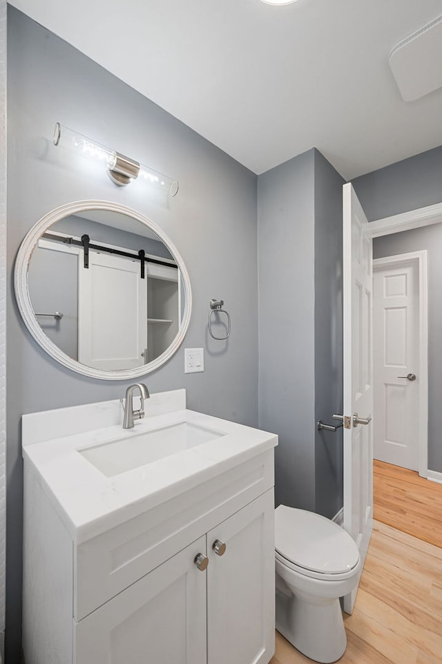 bathroom featuring vanity, toilet, and hardwood / wood-style flooring