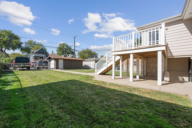 view of yard featuring a garage, a patio, a wooden deck, and a shed