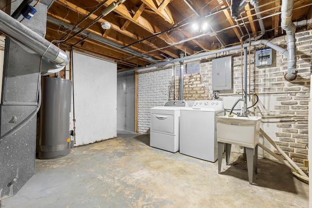 basement with washer and clothes dryer, water heater, brick wall, and electric panel