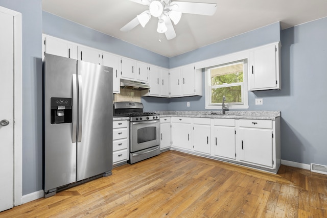 kitchen with ceiling fan, sink, white cabinetry, appliances with stainless steel finishes, and light hardwood / wood-style floors