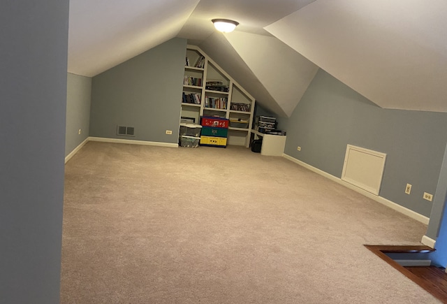 additional living space featuring carpet floors and vaulted ceiling