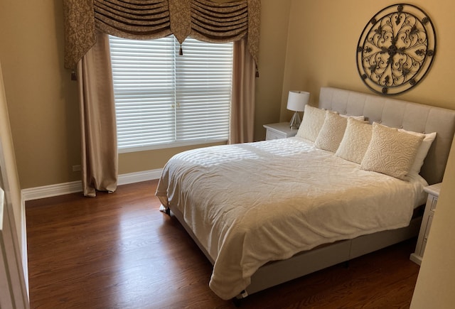 bedroom with dark hardwood / wood-style floors