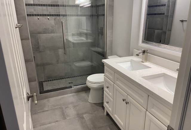 bathroom featuring toilet, vanity, and walk in shower