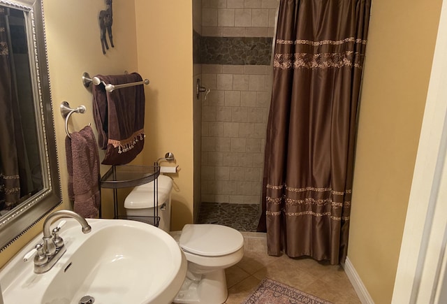 bathroom featuring toilet, tile patterned floors, walk in shower, and sink