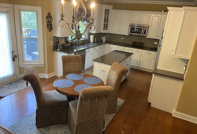 kitchen with white cabinets, a wealth of natural light, dark hardwood / wood-style floors, and appliances with stainless steel finishes