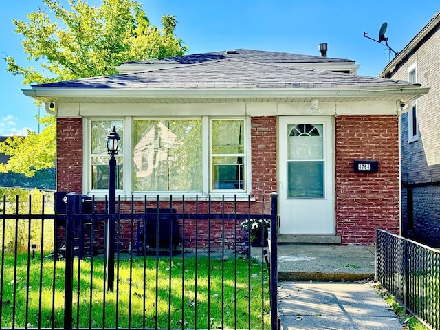 4764 S Shields Ave, Chicago, IL 60609 - bungalow featuring brick siding, a fenced front yard, and roof with shingles