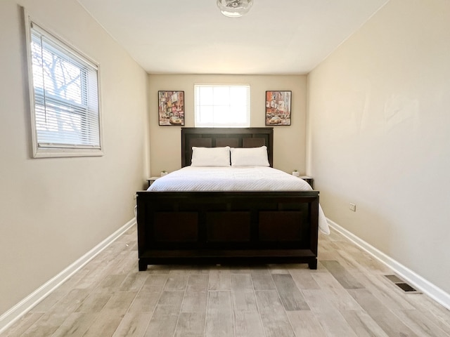 bedroom featuring light hardwood / wood-style floors and multiple windows