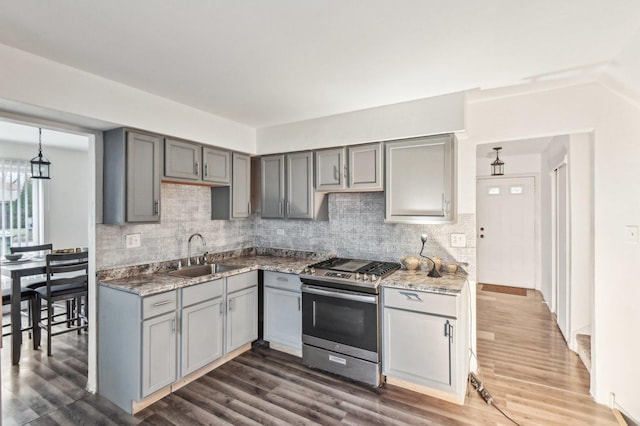 kitchen with gray cabinetry, dark wood-type flooring, sink, tasteful backsplash, and gas stove