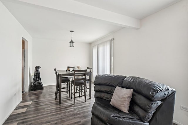 dining area with beam ceiling and dark hardwood / wood-style flooring