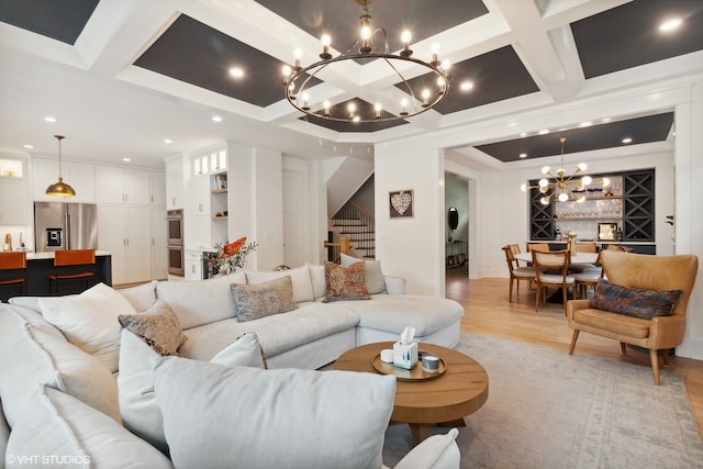 living room with beamed ceiling, light hardwood / wood-style floors, coffered ceiling, and a chandelier